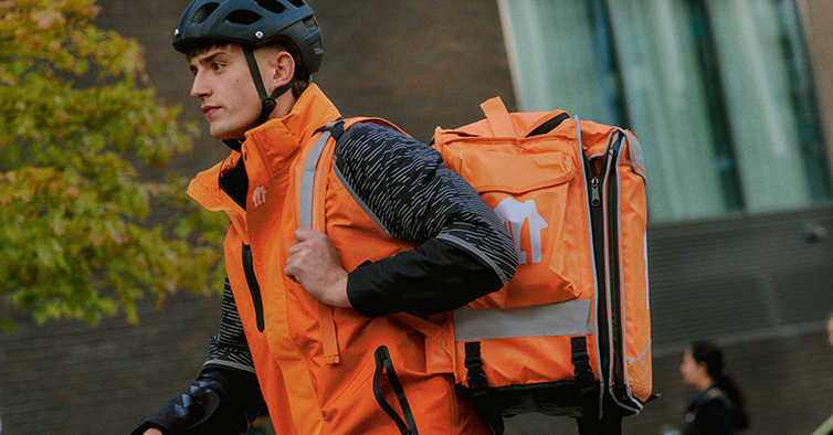 Lieferando Kurier mit Rucksack und Helm